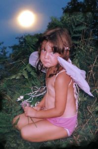 early photo of Marika Warden with angel wings taken by Robin botie of Ithaca, New York at the old Michigan Wymyn's Music Festival